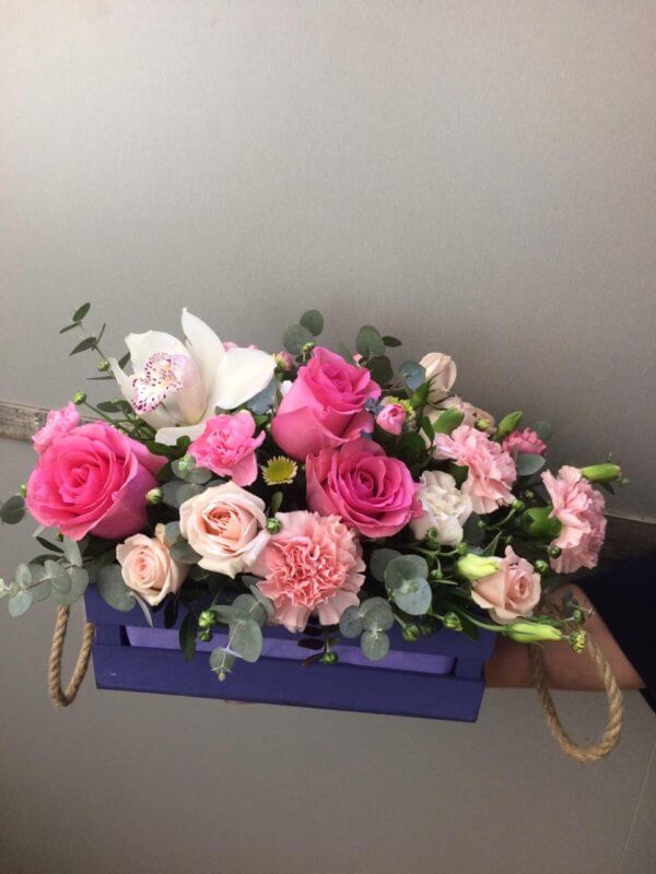 Цветочная композиция в виде ящика с розами, орхидеей и декоративной зеленью