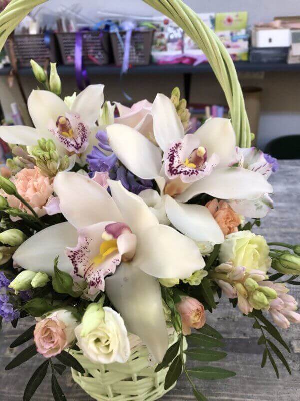 Плетеная корзинка с орхидеями , кустовыми розами и декоративной зеленью