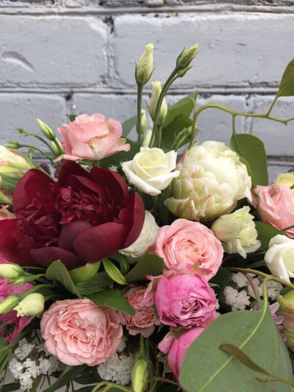 Ящик цветов с красным пионом, пионовидным тюльпаном, кустовой розой, эустомой и декоративной зеленью