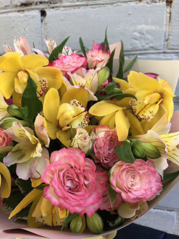 Букет с орхидеями, кустовой розой, альстромерией и декоративной зеленью в крафтовой упаковке