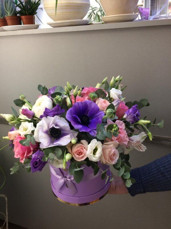 Фиолетовая шляпная коробка с пионовидными розами, анемонами, эустомой, альстромерией, гвоздикой и эвкалиптом