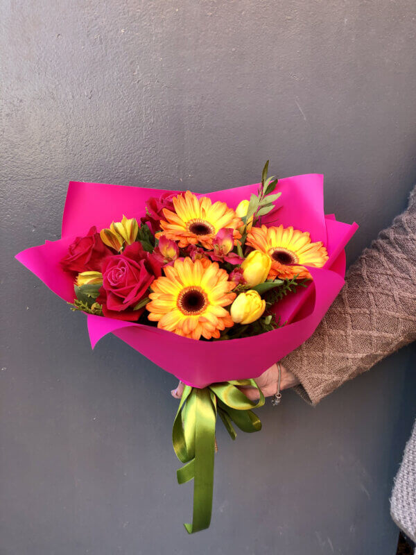 Букет с герберой, альстромерией, тюльпанами, розой и декоративной зеленью в упаковке